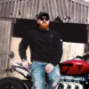 A Man wearing the AJ Stealth Sweatshirt sat on his motorbike