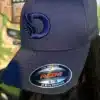 Front view of a woman wearing the DROW Navy FlexFit Cap featuring the iconic Embrodered D logos.